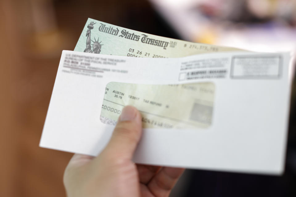 Man receives a tax refund check from the government; Indoor background