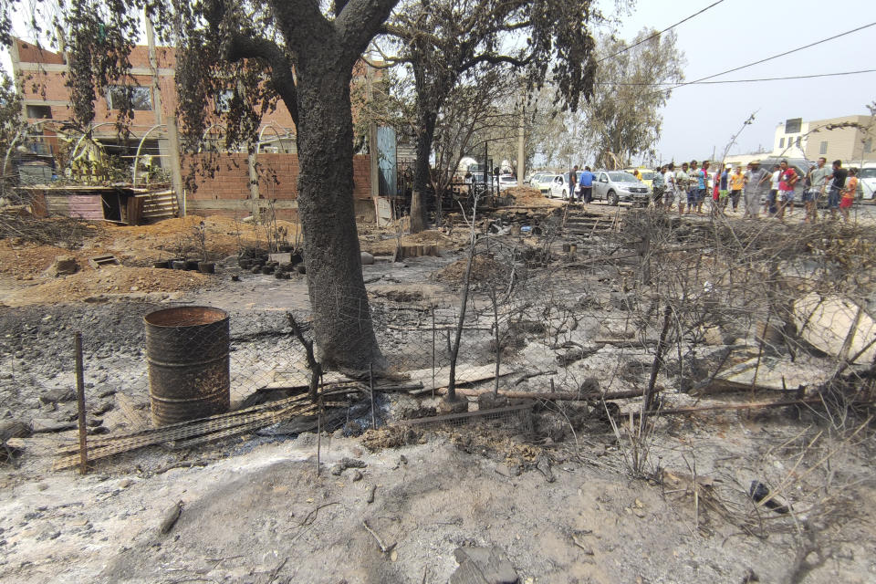 Residents watch the charred vegetation in El Kala, in the El Tarf region, near the northern Algerian-Tunisian border, Thursday, Aug.18, 2022. Wildfires raging in the forests of eastern Algeria have killed at least 26 people, according to a "provisional report" by the north African country's interior minister. (AP Photo/Mohamed Ali)