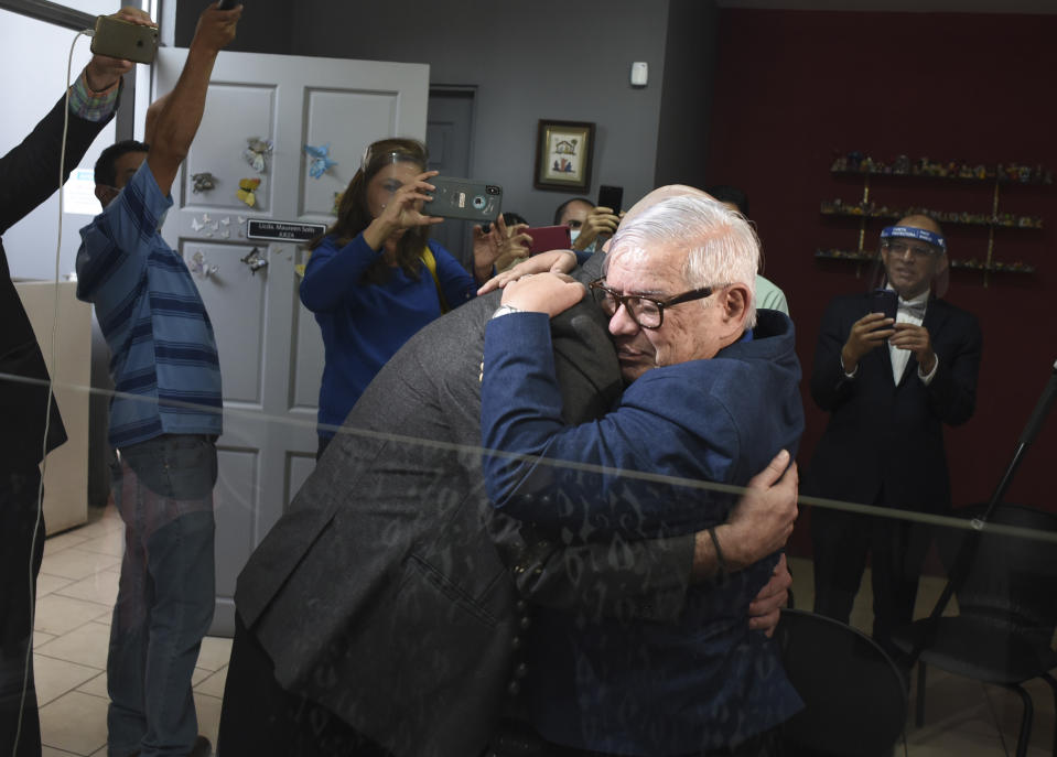 Gay equality activist Marco Castillo, right, embraces his longtime partner Rodrigo Campos, after they were married before a judge, in San Jose, Costa Rica, Tuesday, May 26, 2020. Costa Rica became the latest country to legalize same-sex marriage early Tuesday when a ruling from its supreme court went into effect ending the country's ban. (AP Photo/Carlos Gonzalez)