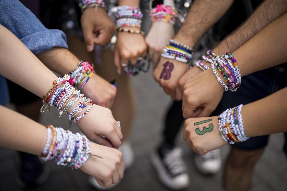 Taylor Swift fans pose with their bracelets outside Wembley Stadium before the first London concert of the Eras Tour on Friday, June 21, 2024 in London. (Photo by Scott A Garfitt/Invision/AP)