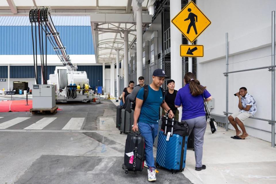 Passengers board a cruise ship before the start of a ribbon cutting event at PortMiami on Monday, June 17, 2024, in Miami, Fla. The event officially launched shore power at PortMiami, allowing cruise ships to turn off their engines and plug into a land side electrical power (pictured on left) while docked, resulting in reduced emissions and noise.