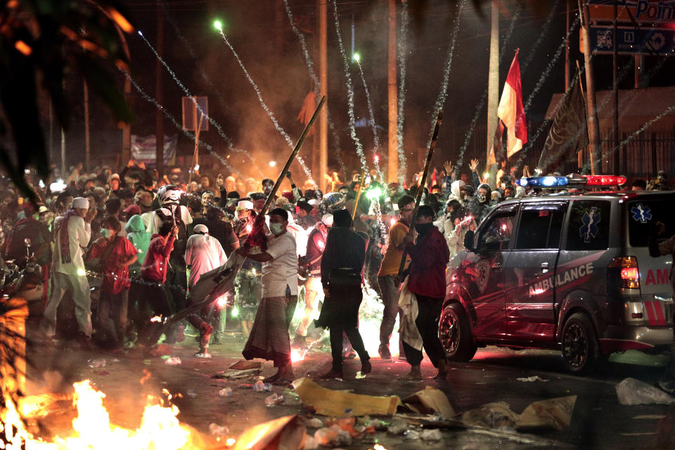 Firecrackers explode near supporters of presidential candidate Prabowo Subianto during clashes with the police in Jakarta, Indonesia, Wednesday, May 22, 2019. Seven people have died in election violence in the Indonesian capital, police said Thursday, as calm returned to the city and the losing presidential candidate prepared the challenge the result in court. (AP Photo/Dita Alangkara)