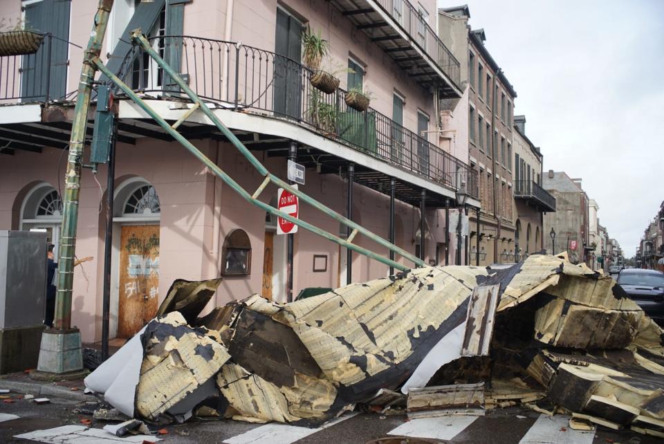 A pink building is seen behind a huge pile of rubble