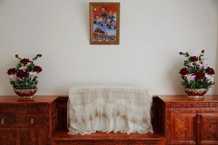A picture of former and present Chinese leader hangs over a covered TV set and some plastic flowers decorating a room for orphans at a newly built Lhasa Children Welfare House in Lhasa, Tibet Autonomous Region, China November 19, 2015. REUTERS/Damir Sagolj/Files