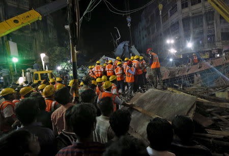 Firefighters and rescue workers search for victims at the site of an under-construction flyover after it collapsed in Kolkata, India, March 31, 2016. REUTERS/Rupak De Chowdhuri