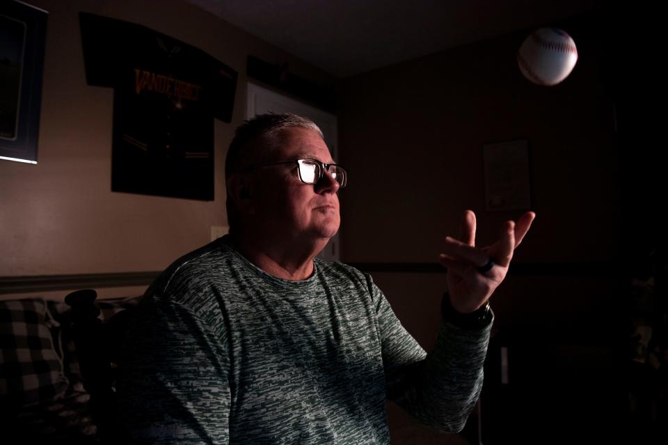 Jeff Edwards, throws a baseball while sitting in a room in his home where his baseball memorabilia is displayed at his home in Mt. Juliet, Tenn., Thursday, March 28, 2024.