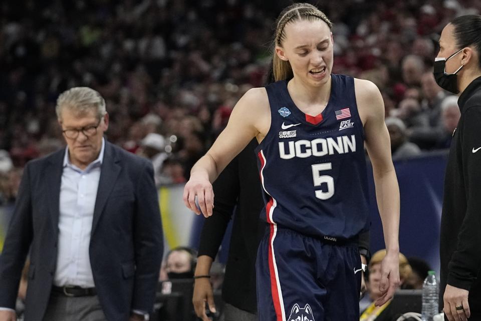 FILE- Connecticut's Paige Bueckers reacts as she heads to the bench during the second half of an NCAA college basketball game in the semifinal round of the Women's Final Four tournament on April 1, 2022, in Minneapolis. Bueckers tore the ACL in her left knee and will miss the entire 2022-23 season, the school announced Wednesday, Aug. 3, 2022. (AP Photo/Eric Gay, File)