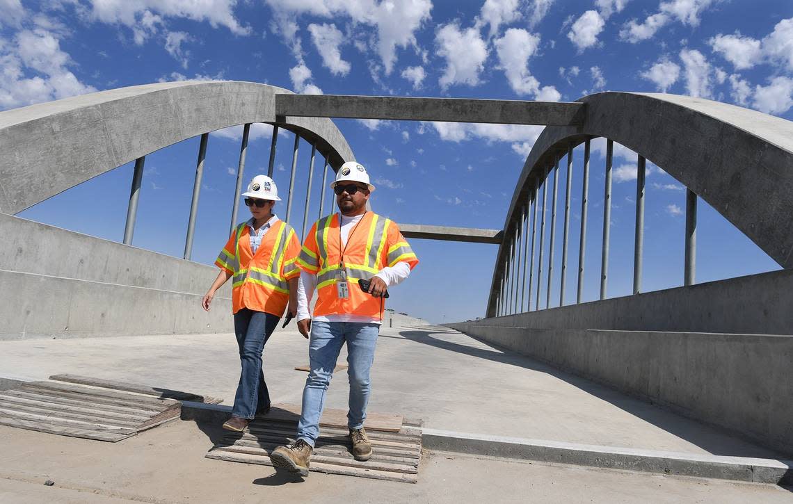 Toni Tinoco, Central Valley Deputy Regional Director at California High-Speed Rail Authority, left, and Augie Blancas, HSR public information officer, check out the rails viaduct over the San Joaquin River during a tour, June 17, 2021.