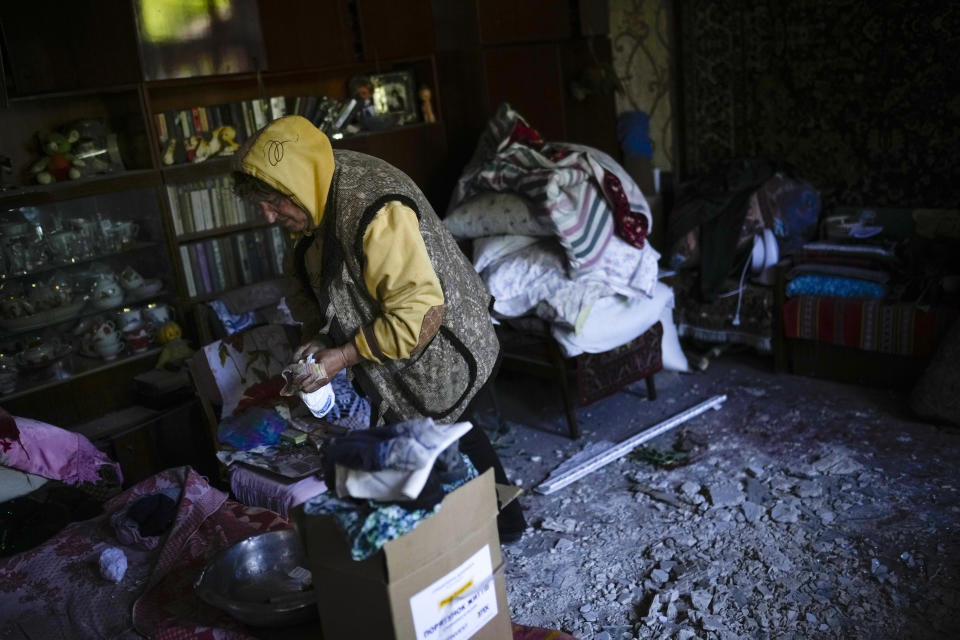 A local resident gathers up belongings from her heavily damaged house after a Russian strike in Pokrovsk, eastern Ukraine, Wednesday, May 25, 2022. Two rockets struck the eastern Ukrainian town of Pokrovsk, in the Donetsk region early Wednesday morning, causing at least four injuries. (AP Photo/Francisco Seco)