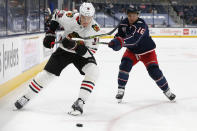 Chicago Blackhawks' Nikita Zadorov, left, and Columbus Blue Jackets' Max Domi chase the puck during the second period of an NHL hockey game Saturday, April 10, 2021, in Columbus, Ohio. (AP Photo/Jay LaPrete)