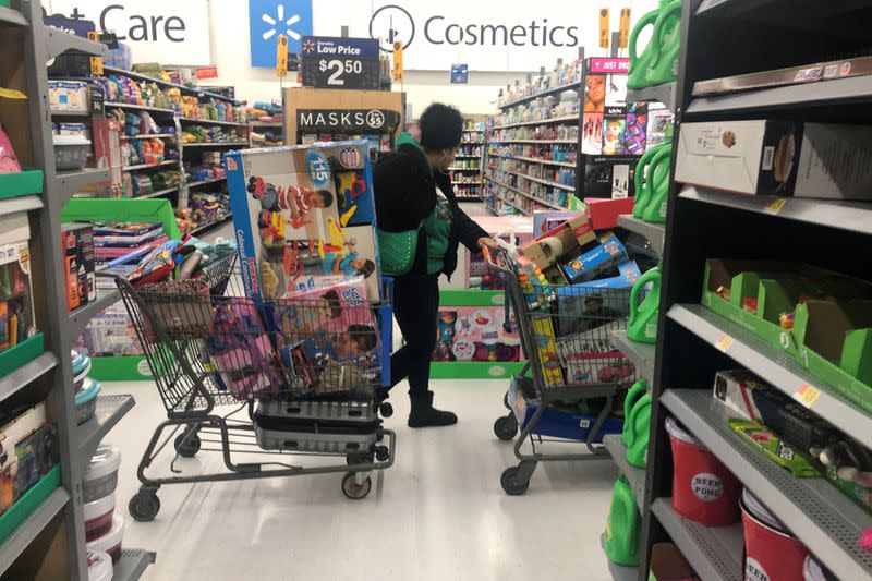 FILE PHOTO: A woman pushes shopping carts during a sales event on Thanksgiving day at Walmart in Westbury, New York