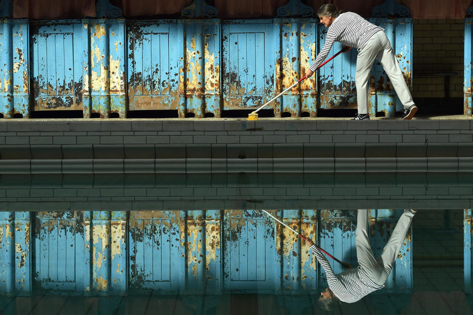 <p>A staff member sweeps the poolside of the Men’s First Class pool at Victoria Baths, which opened for the first time in over 20 years for a one-off public swimming event, May 14, 2017, in Manchester, England. (Photo: Anthony Devlin/Getty Images) </p>