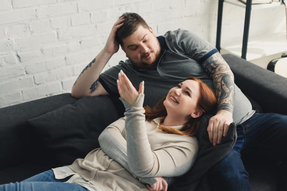 A man and a woman talking on a sofa