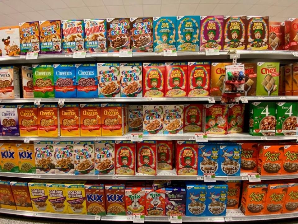 Supermarket cereal aisle with various brand boxes on shelves