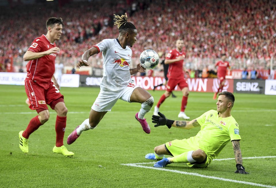 Leipzig's Christopher Nkunku, centre vies for the ball with Union's Rafal Gikiewicz , right and Keven Schlotterbeck, during the German Bundesliga soccer match between Union Berlin and RB Leipzig, at the Stadion An der Alten Foersterei, in Berlin, Sunday, Aug. 18, 2019. (Britta Pedersen/dpa via AP)