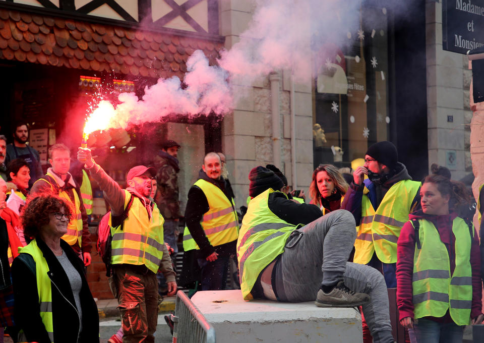 Demonstrators wearing yellow vests gather during a visit by French Foreign Minister Jean-Yves Le Drian in Biarritz, southwestern France, Tuesday, Dec. 18, 2018. Yellow vest protesters occupied dozens of traffic roundabouts across France even as their movement for economic justice appeared to be losing momentum on the fifth straight weekend of protests. (AP Photo/Bob Edme)