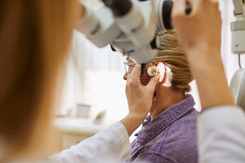 ENT physician examining ear of a senior woman