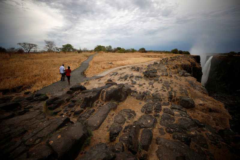 Visitors walk along a walkway after a prolonged drought near Victoria Falls