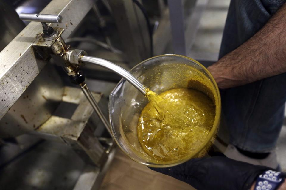 FILE – In this April 24, 2018, file photo, the first rendering from hemp plants extracted from a super critical CO2 extraction device on its’ way to becoming fully refined CBD oil spurts into a large beaker at New Earth Biosciences in Salem, Ore. Sens. (AP Photo/Don Ryan, File)