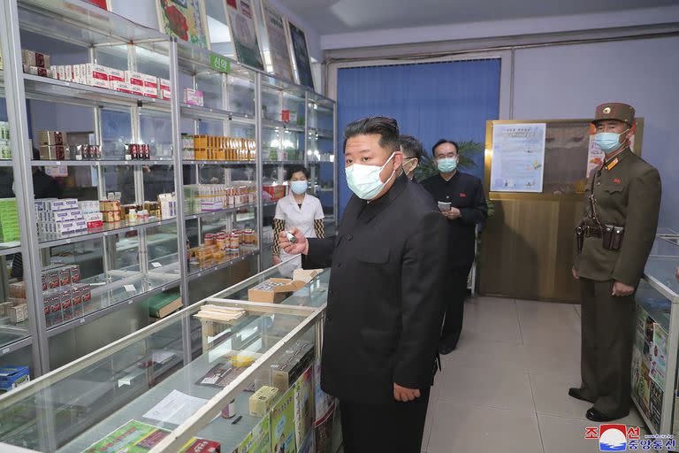 En esta foto proporcionada por el gobierno de Corea del Norte, el líder norcoreano Kim Jong Un, en el centro, visita una farmacia en Pyongyang, Corea del Norte, el domingo 15 de mayo de 2022