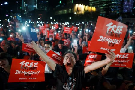 Demonstrators wave their smartphones during a rally ahead of the G20 summit, urging the international community to back their demands for the government to withdraw a the extradition bill in Hong Kong