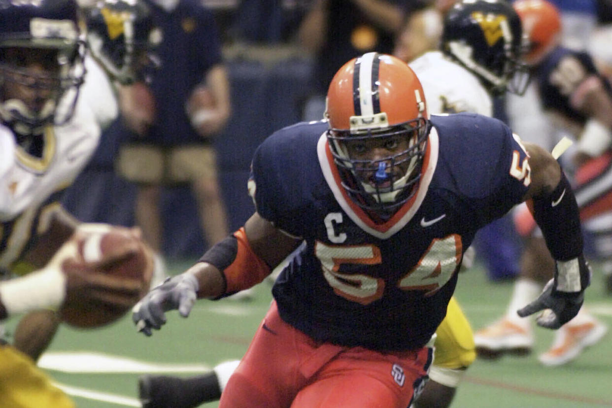 FILE - In this Nov. 10, 2001, file photo, Syracuse defensive end Dwight Freeney (54) bares down on West Virginia quarterback Rasheed Marshall during the fourth quarter of an NCAA college football game in Syracuse, N.Y. , Nov. 10, 2001. Freeney was elected to the College Football Hall of Fame on Monday, Jan. 9, 2023. (AP Photo/Kevin Rivoli, File)