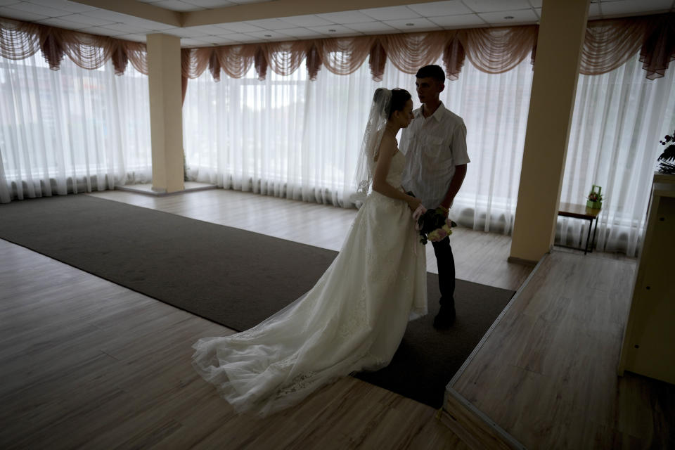 Yevhen Levchenko and Nadiia Prytula get married in Irpin, on the outskirts of Kyiv, Ukraine, Tuesday, June 21, 2022. After the wedding the couple must separate, Nadiia goes to study abroad and Yevhen stays because men cannot leave the country. A growing number of couples in Ukraine are speedily turning love into matrimony because of the war with Russia. Some are soldiers, marrying just before they head off to fight. Others are united in determination that living and loving to the full are more important than ever in the face of death and destruction. (AP Photo/Natacha Pisarenko)