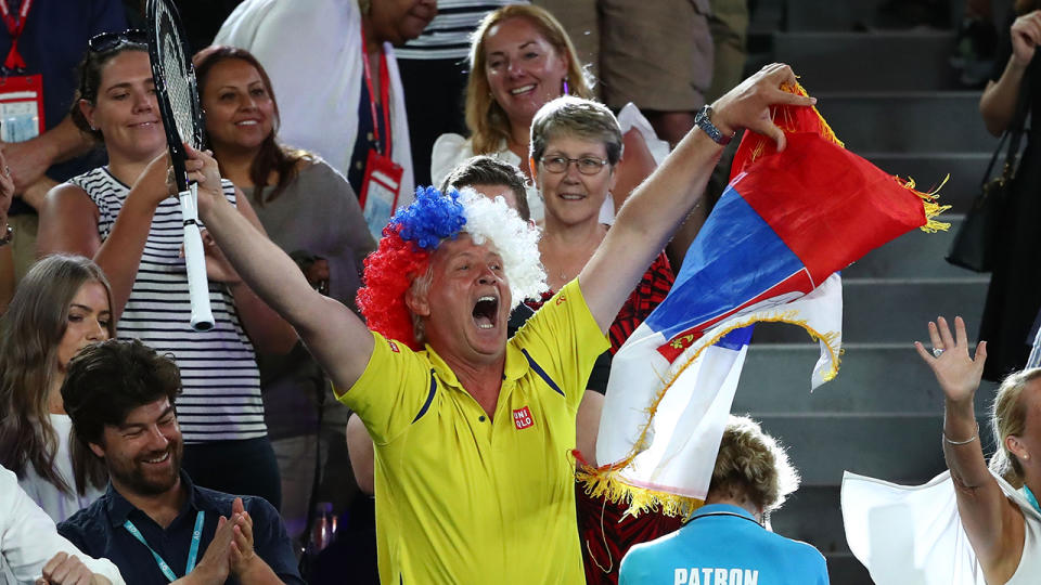 A fan celebrates in the crowd after receiving Novak Djokovic’s racquet. (Photo by Cameron Spencer/Getty Images)