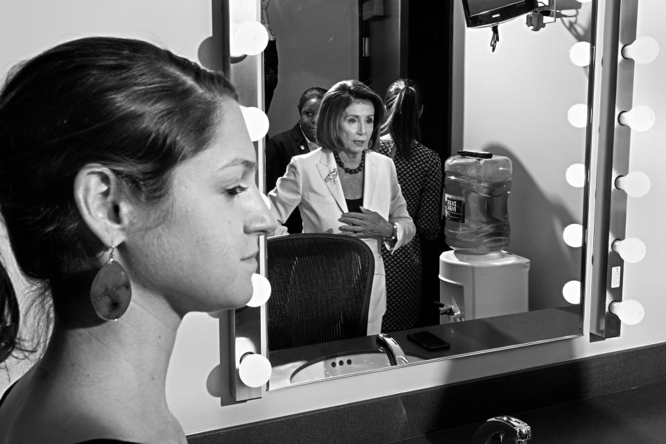 Pelosi prepares for a press conference on December 5 as an aide looks on. | Philip Montgomery for TIME