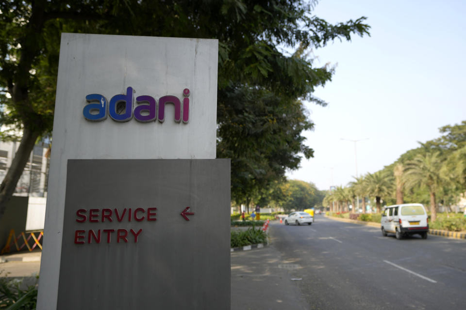 FILE- Vehicles move past a signage near the entrance of Adani Corporate House in Ahmedabad, India, Friday, Jan. 27, 2023. Embattled Indian billionaire Gautam Adani said Thursday his conglomerate will review its plans for raising capital after calling off his flagship company’s $2.5 billion share following the loss of tens of billions of dollars in market value due to claims of fraud by a U.S.-based short-selling firm. (AP Photo/Ajit Solanki, File)