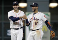 Houston Astros shortstop Carlos Correa (1) reacts with second baseman Yuli Gurriel (10) after fielding a ground ball by Colorado Rockies' Tony Wolters and throwing to first for the out during the ninth inning of a baseball game Wednesday, Aug. 15, 2018, in Houston. The Astros won 12-1. (AP Photo/David J. Phillip)