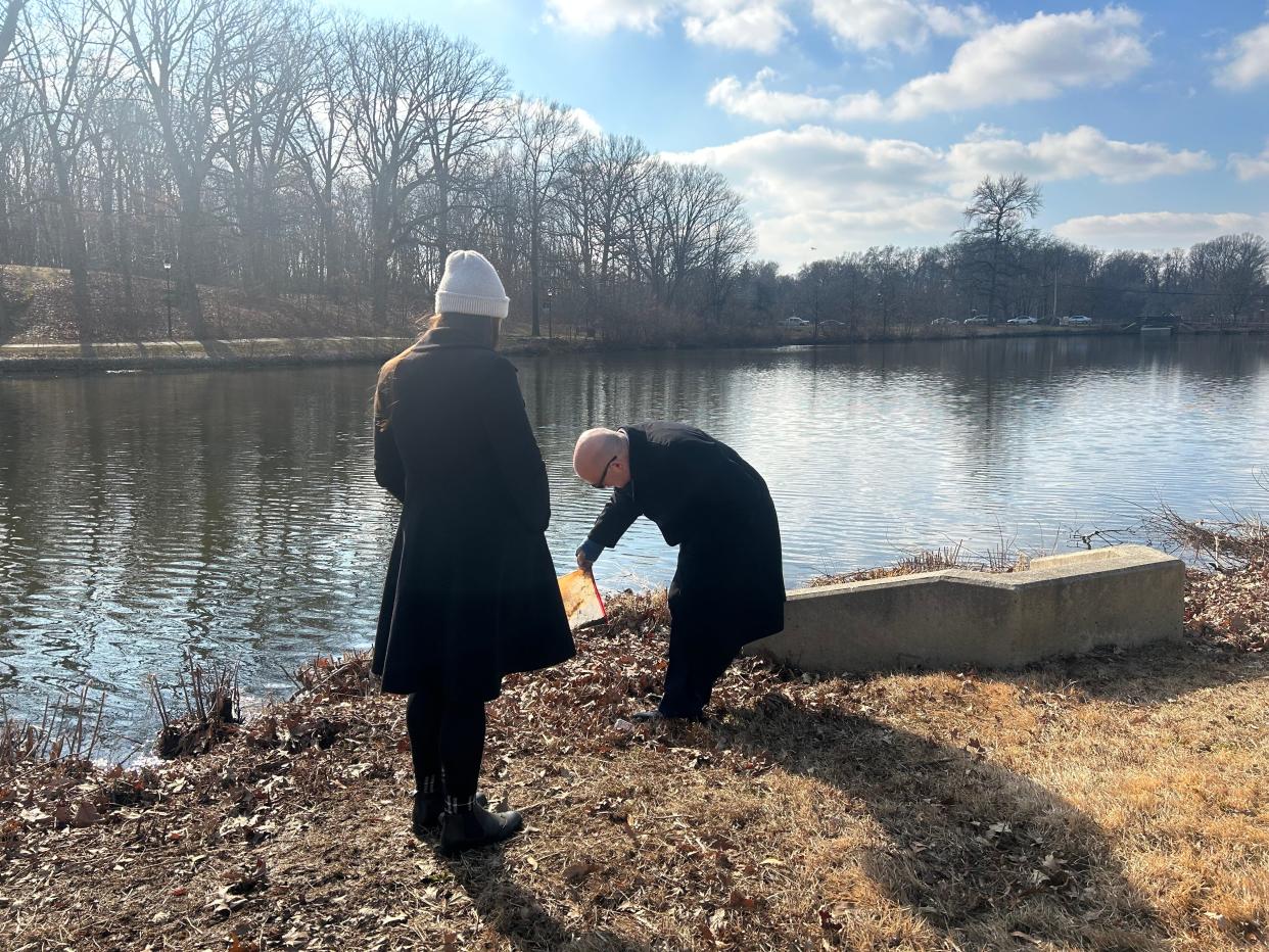 Camden County Commissioner Jeff Nash picks up a piece of trash at Newton Creek Park in Haddon Township as Maggie McCann Johns, director of the county parks department, watches.