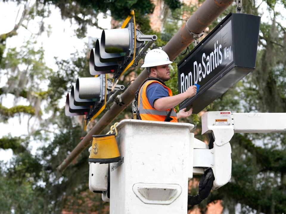 Zackary Atkins hangs a street sign with the name of Florida Gov. Ron DeSantis in preparation for the inauguration of the governor, Monday, January 2, 2023, at the Old Capitol in Tallahassee, Florida.