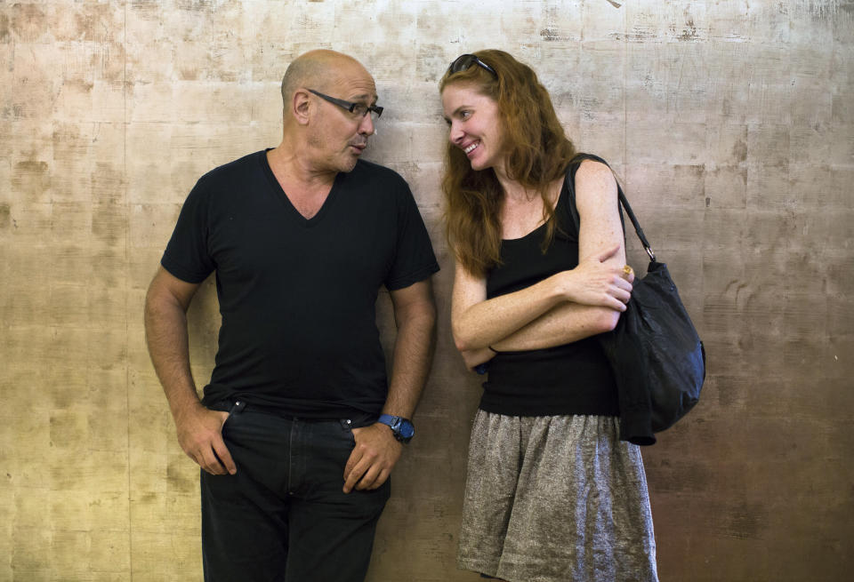 In this Aug. 30, 2013, photo, fashion designer Carmen Marc Valvo, left, talks to model Taylor Foster at Valvo's New York studio. Valvo will show his Spring 2014 collection on Sept. 6 at Lincoln Center in New York. (AP Photo/John Minchillo)