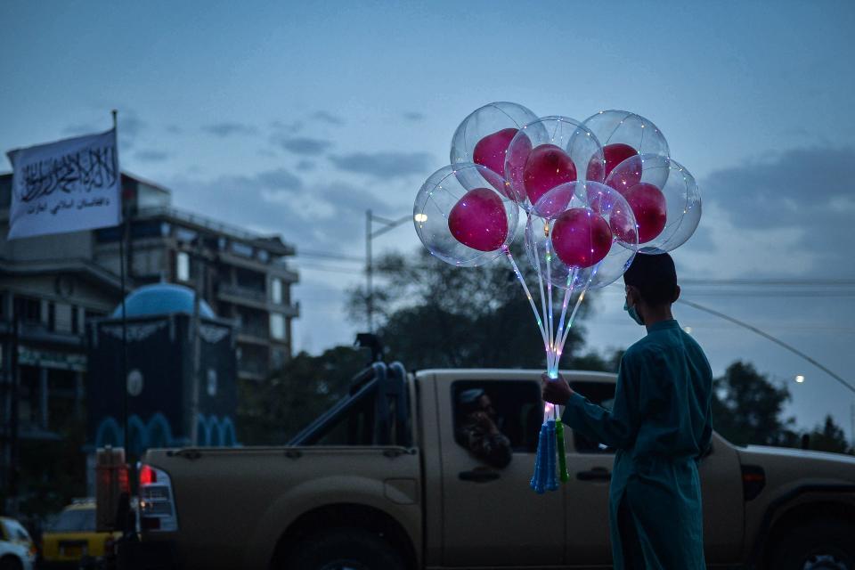 An Afghan boy stands along a road holding a bunch of balloons to sell in Kabul on Monday (AFP via Getty Images)