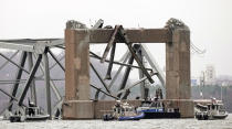 Police dive boats work around part of the structure of the Francis Scott Key Bridge after the ship hit the bridge Wednesday, March 27, 2024, in Baltimore, Md. (AP Photo/Steve Helber)