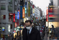 A commuter rides an escalator up toward a train station Tuesday, April 7, 2020, in Tokyo .Japanese Prime Minister Shinzo Abe declared a state of emergency on Tuesday for Tokyo and six other prefectures to ramp up defenses against the spread of the coronavirus. (AP Photo/Jae C. Hong)