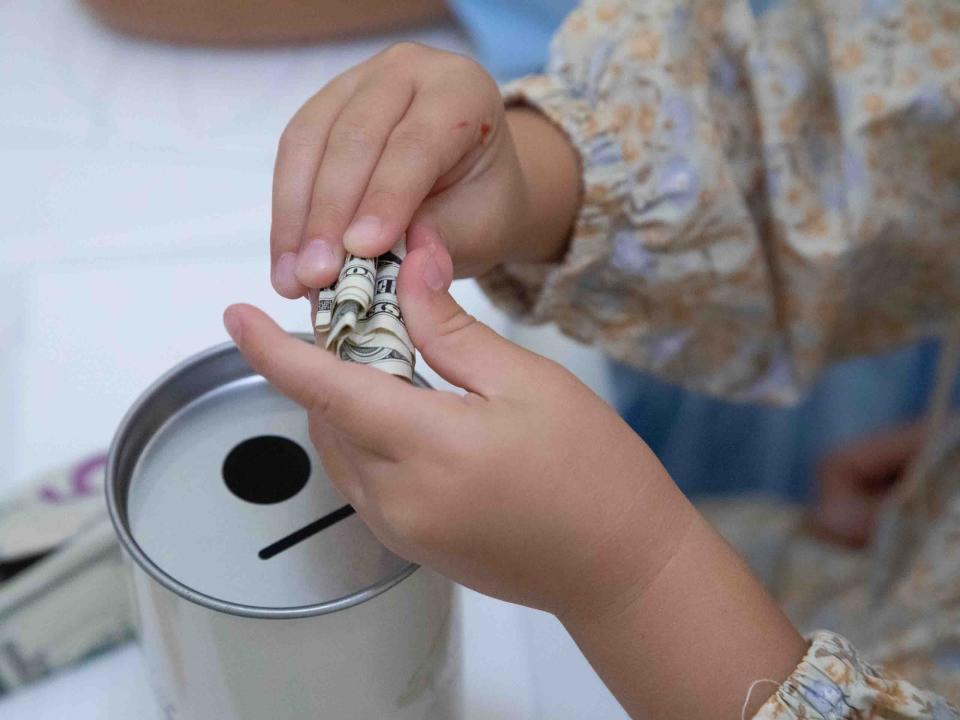 A child prepares to place a donation in a tzedakah box at a "Mitzvah for Israel" pop-up store Thursday at The Chabad House.