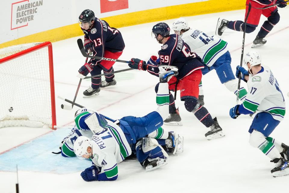 Jan 15, 2024; Columbus, Ohio, USA; Columbus Blue Jackets right wing Yegor Chinakhov (59) and left wing Johnny Gaudreau (13) to score past Vancouver Canucks goaltender Casey DeSmith (29) in heavy traffic during the second period of the NHL hockey game at Nationwide Arena.