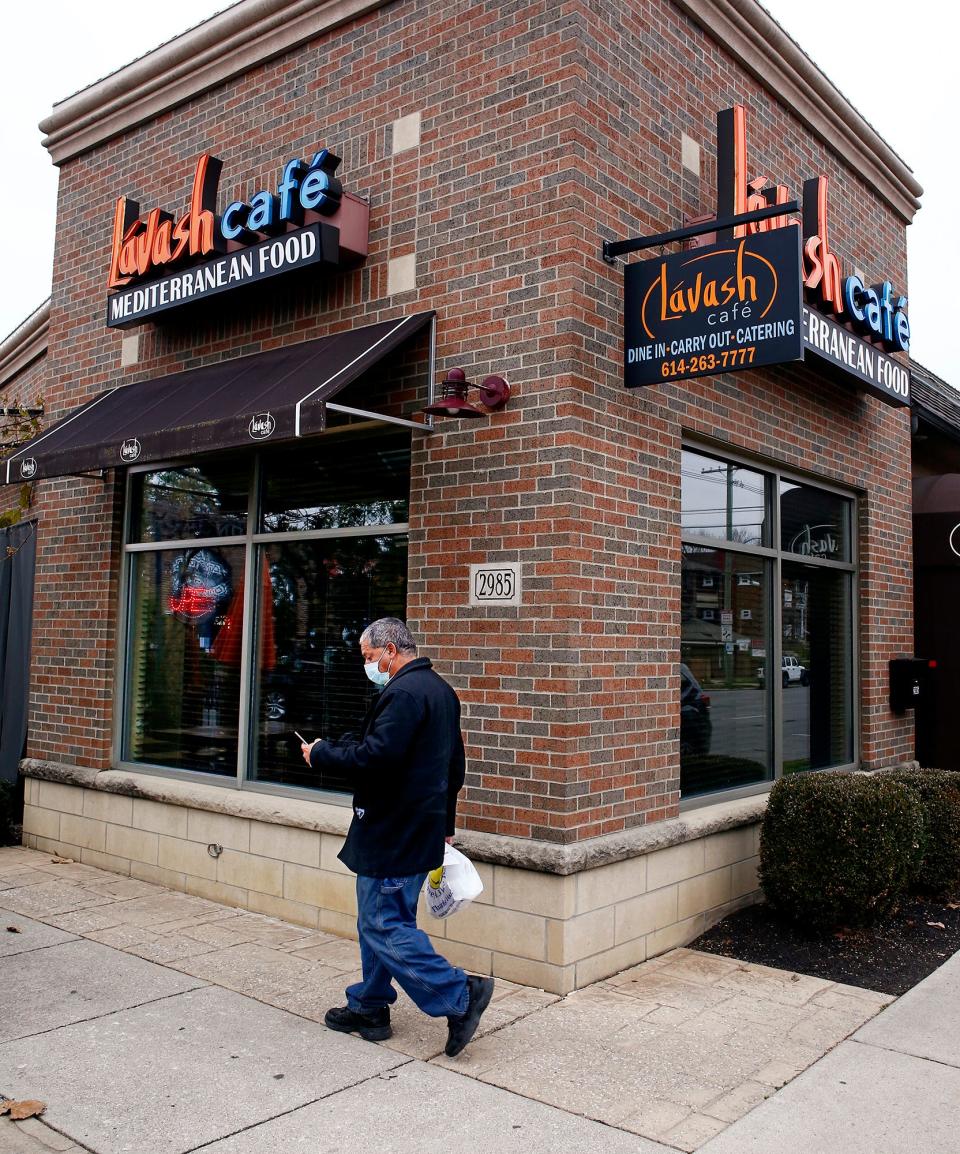 A customer leaves Lavash Cafe with his carry-out order in this 2020 photo.