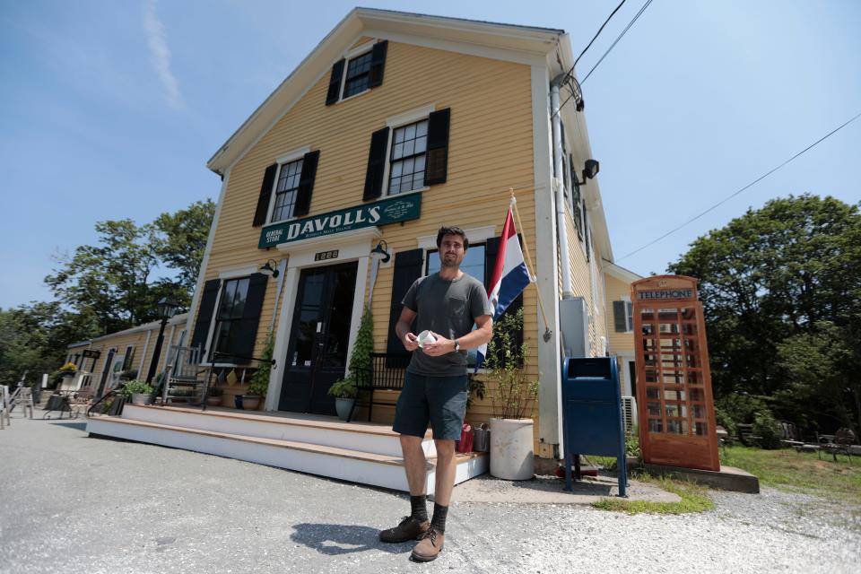 Ben Shattuck walks in front of his newly opened Davoll's General Store on Russells Mills Road in Dartmouth.