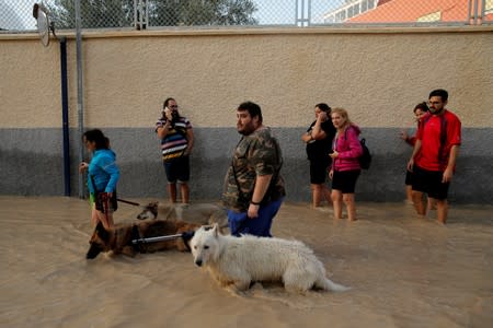 People wade through a flooded street as torrential rains hit Orihuela