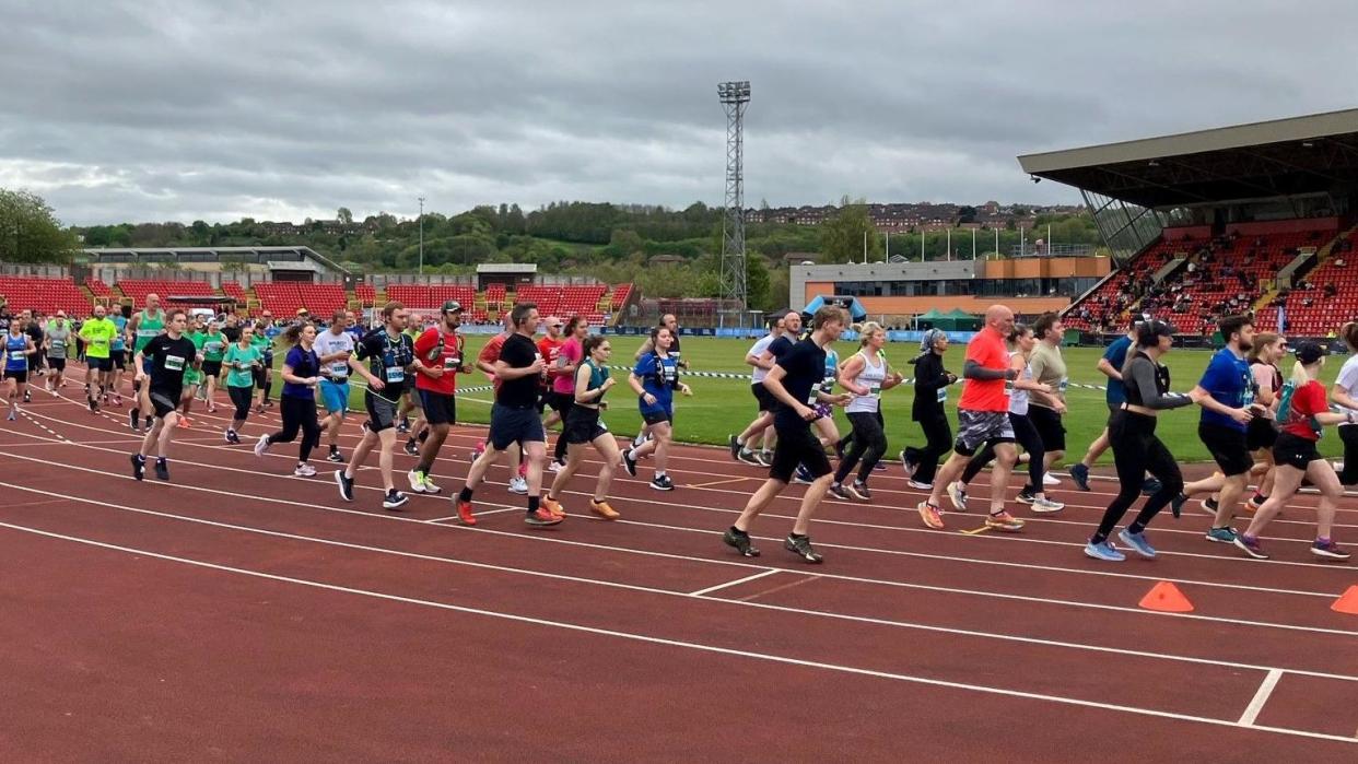 Runners leaving the stadium at the start of a marathon