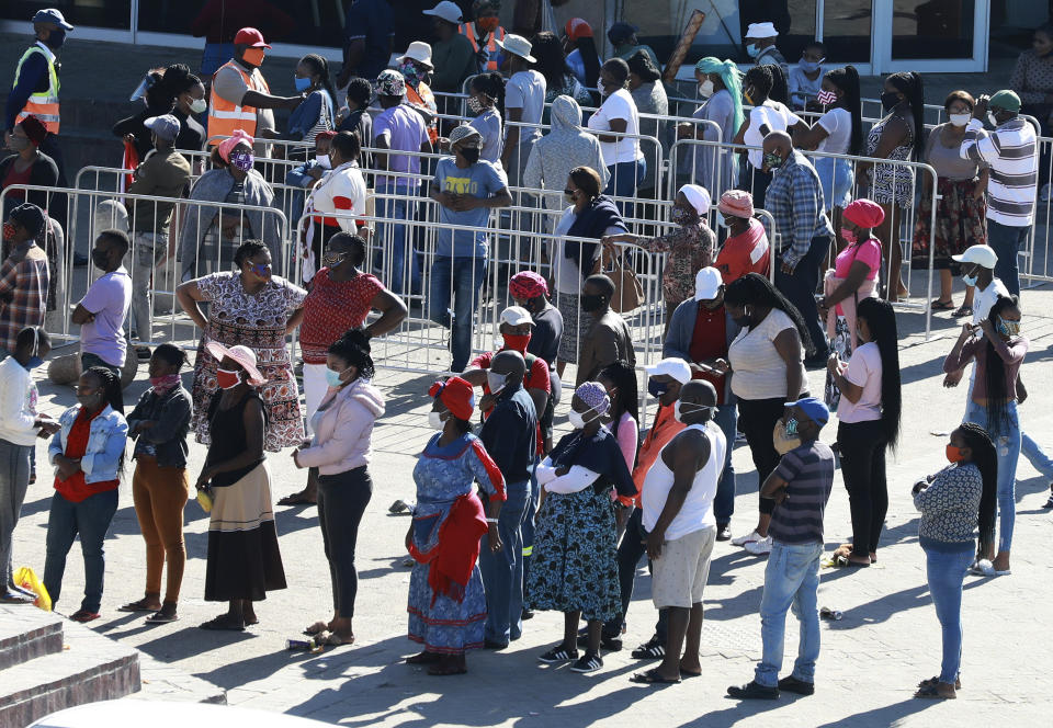 In this photo taken Tuesday, May 19, 2020, customers queue at a mall without practicing social distancing at a mall in Khayelitsha in Cape Town South Africa. With dramatically increased community transmission, Cape Town has become the center of the COVID-19 outbreak in South Africa and the entire continent. (AP Photo/Nardus Engelbrecht)
