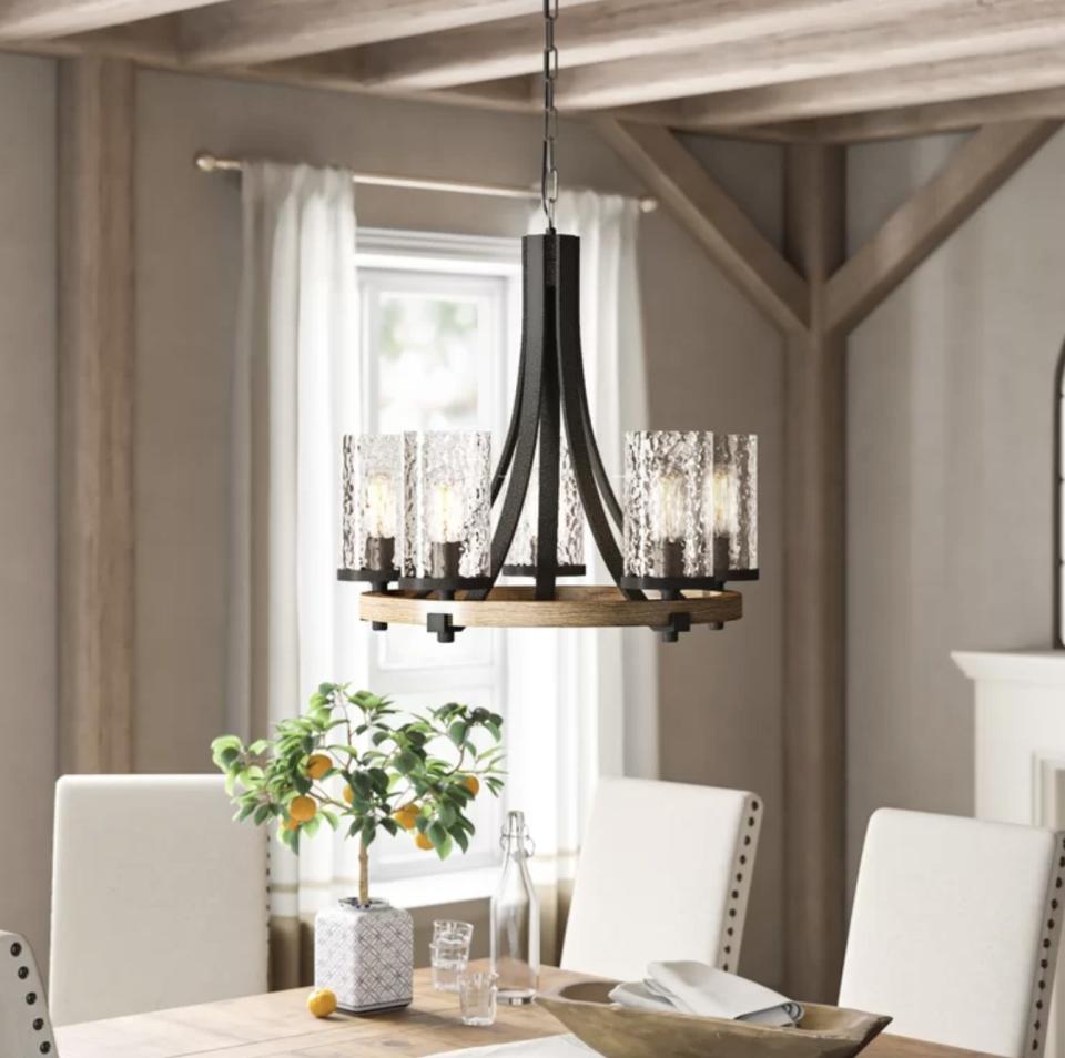 the chandelier with glass light shades and a wooden base 