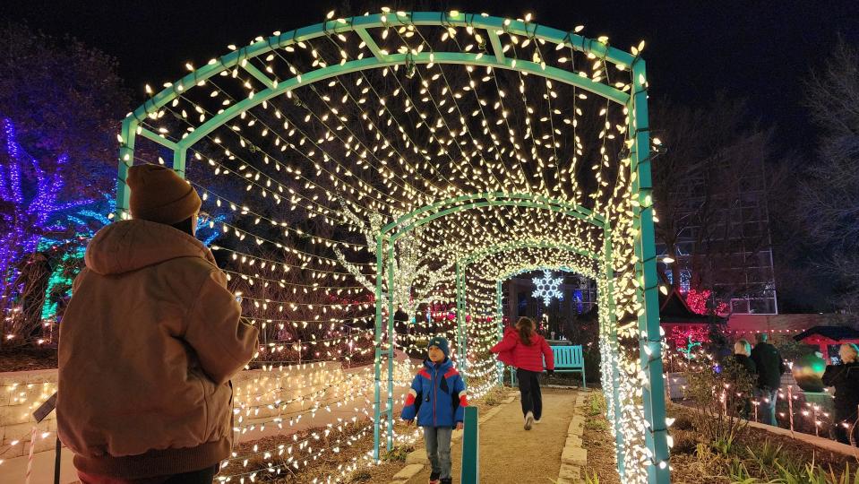 A family enjoys the tunnel of lights in December 2022 at the Amarillo Botanical Gardens during its Christmas in the Gardens event. This year's event runs Dec. 14-23.