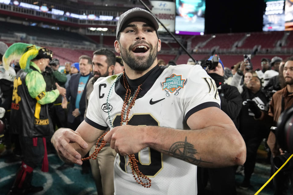 Wake Forest quarterback Sam Hartman throws beads to his teammates after being named Most Valuable Player of the Gasparilla Bowl on Dec. 23, 2022, in Tampa, Fla. (AP Photo/Chris O'Meara)