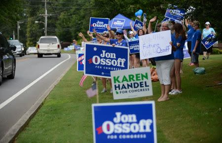 Supporters for Georgia 6th Congressional District Democratic candidate Jon Ossoff rally and wave at passing cars amid signs for Republican candidate Karen Handel outside St Mary's Orthodox Church, Handel's polling place in Roswell, Georgia, U.S., June 20, 2017. REUTERS/Bita Honarvar