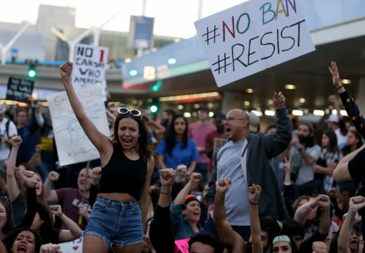 Protesters hold signs as they block a road during a demonstration against the immigration ban imposed by Trump at Los Angeles International Airport on Sunday. (Justin Sullivan/Getty Images)