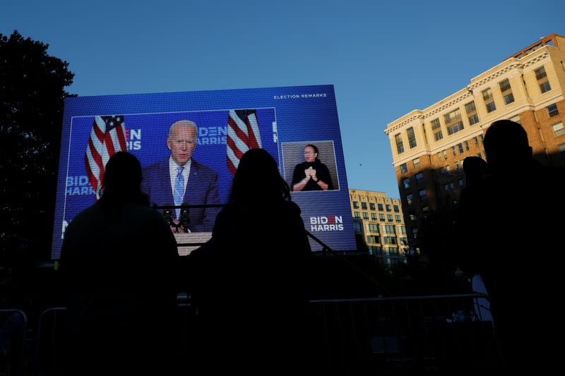 Foto del miércoles de un grupos de personas viendo en Washington al candidato demócrata a la presidencia de EEUU, Joe Biden, hablando en Wilmington, Delaware